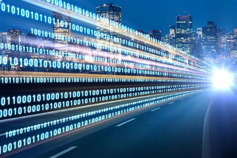 Digital data streams representing east-west traffic across a cityscape at night, symbolizing internal network communication and cybersecurity.