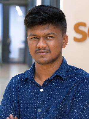 Akash Mandal, Software Engineer at Vehere, wearing a navy blue shirt with white dotted pattern, standing with arms crossed